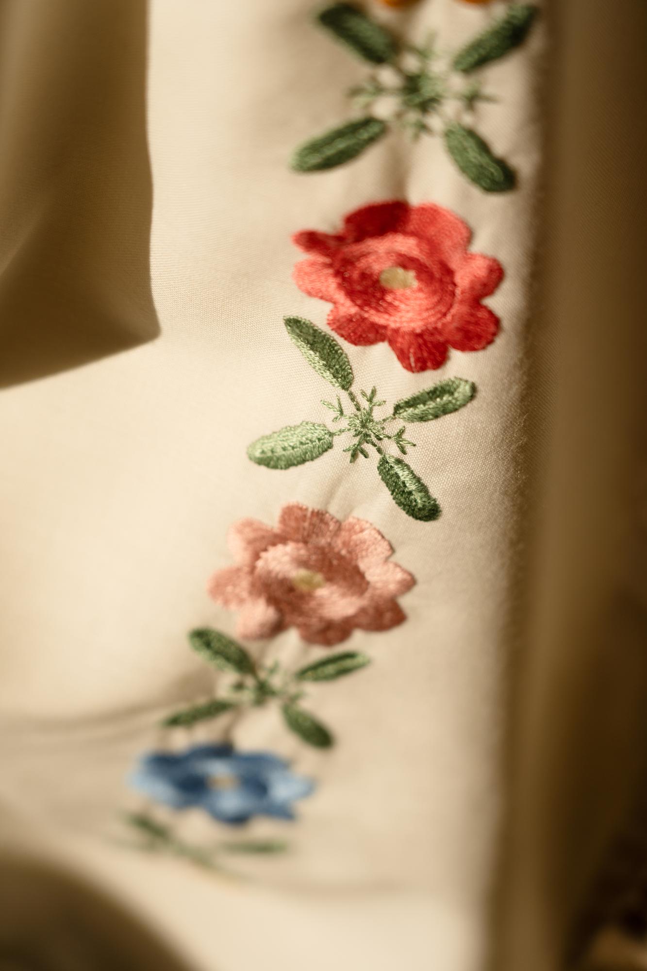 Close-up of hand embroidery on linen with floral motif
